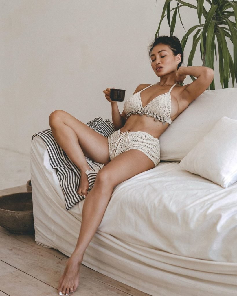 Viviane Leigh modelo oriental sentada no sofá tomando café