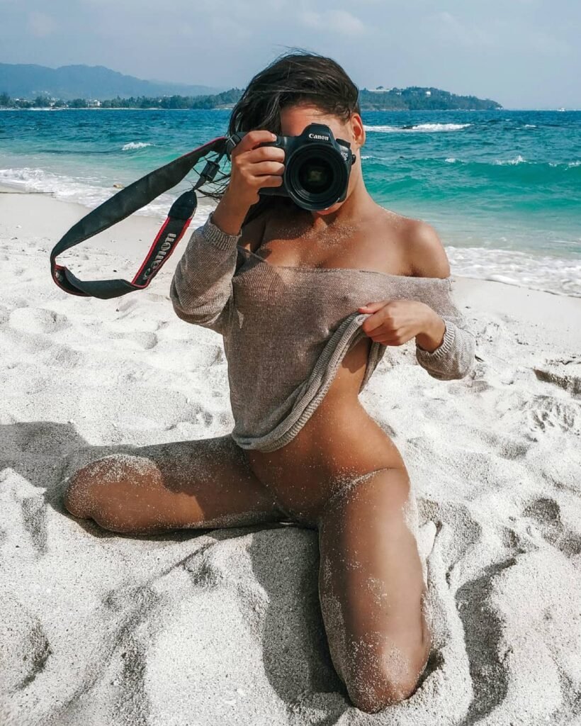 Freyer Fotógrafo - Morena seminua na praia com câmera fotográfica