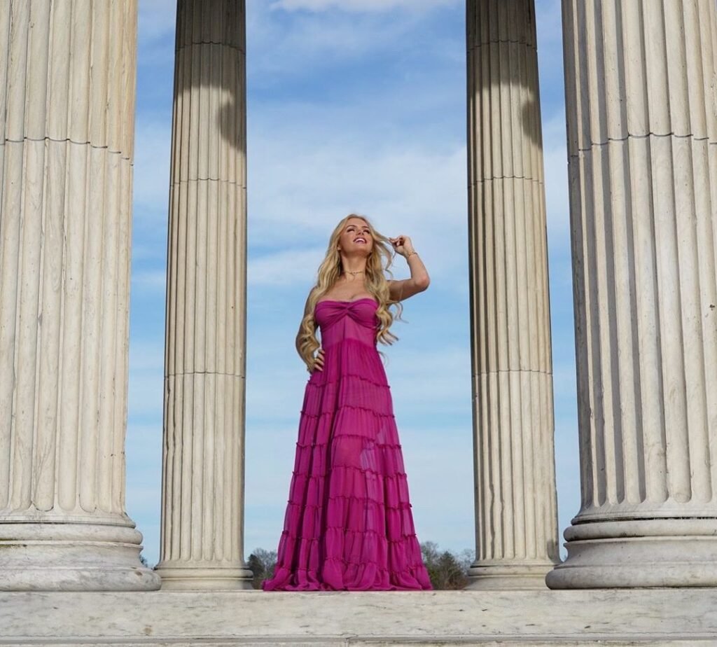 Modelo Thalita Zampirolli de vestido lilás em meio a colunas gregas