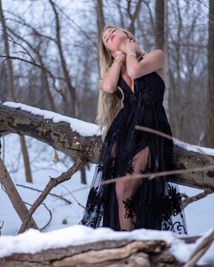 Modelo Thalita Zampirolli usando vestido preto na neve