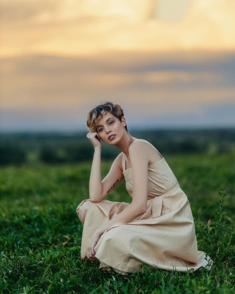 Yelle Nepomuceno Fotógrafa - Modelo posando no campo de vestido com horizonte ao fundo