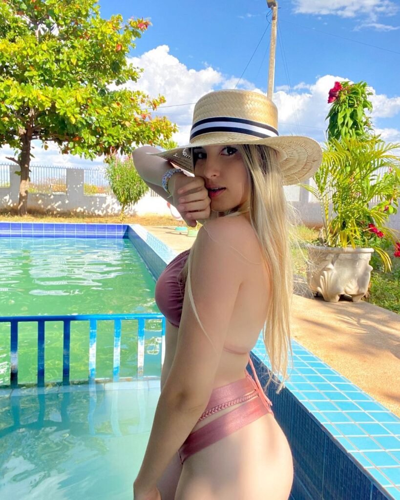Luciana Coutinho influencer na piscina de biquini e chapeu