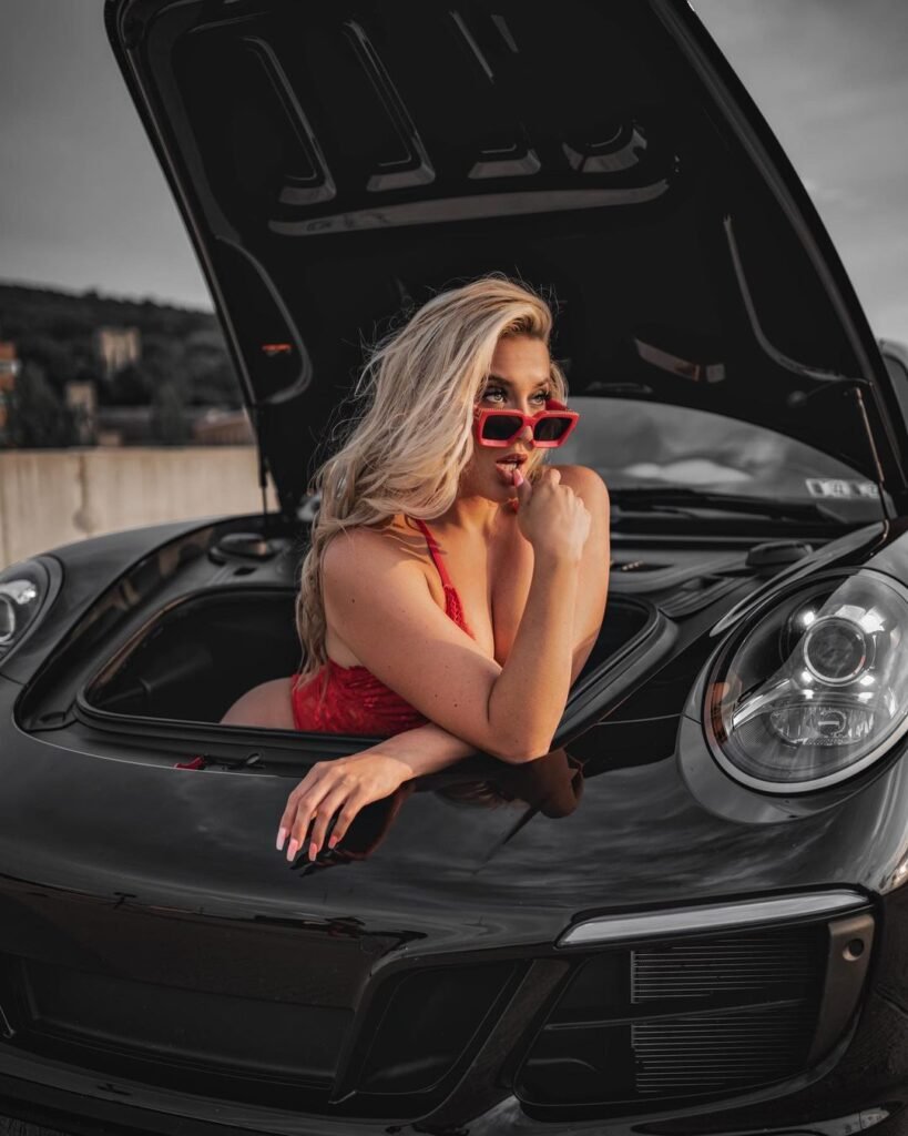Mulheres e Carros - Modelo loira posa dentro do porta mala dianteiro do carro