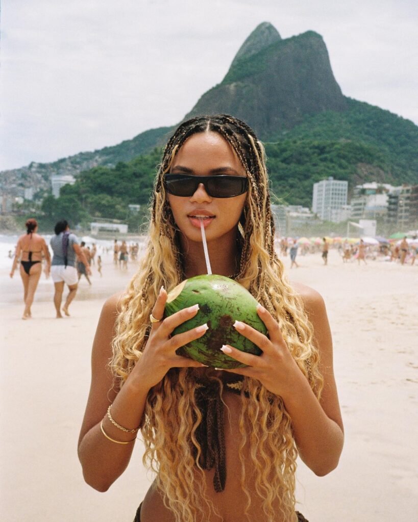 Juliana Nalu Modelo bebendo agua de coco na praia