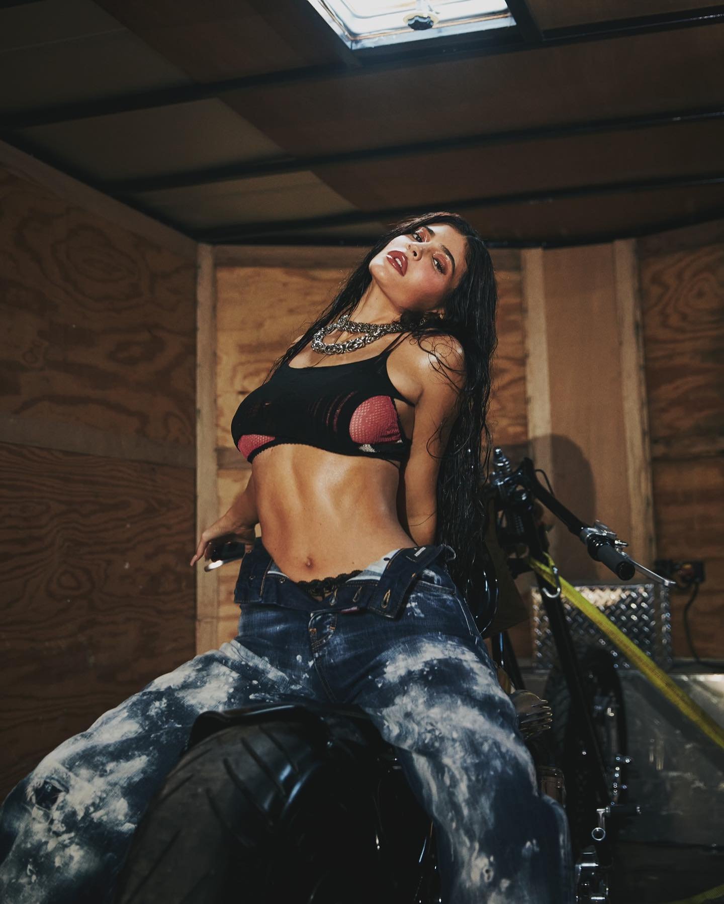 Kylie Jenner modelo posando para ensaio com moto e look radical