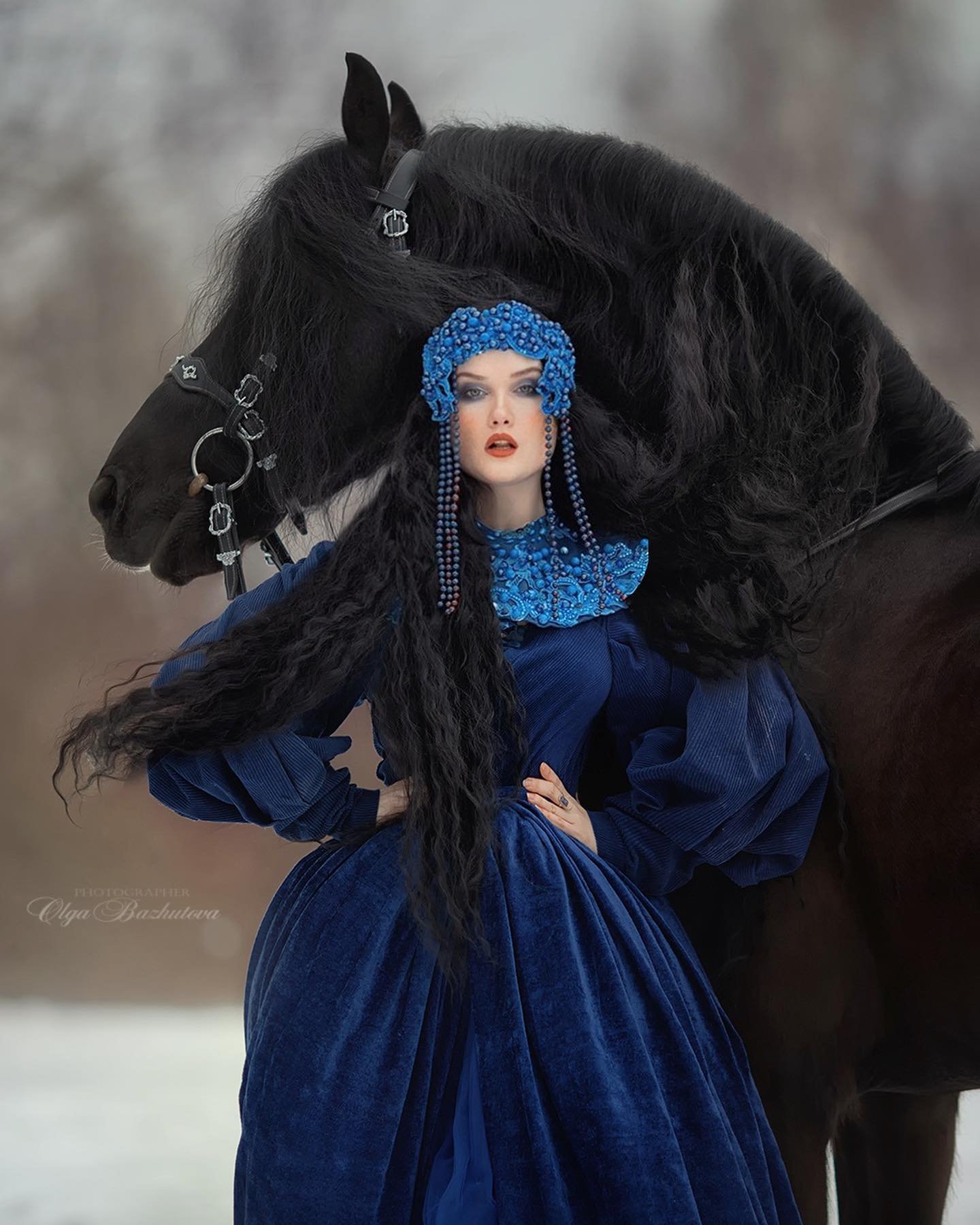 Olga Bazhutova fotografia equestre - Modelo com vestido de inverno azul e posando ao lado de cavalo