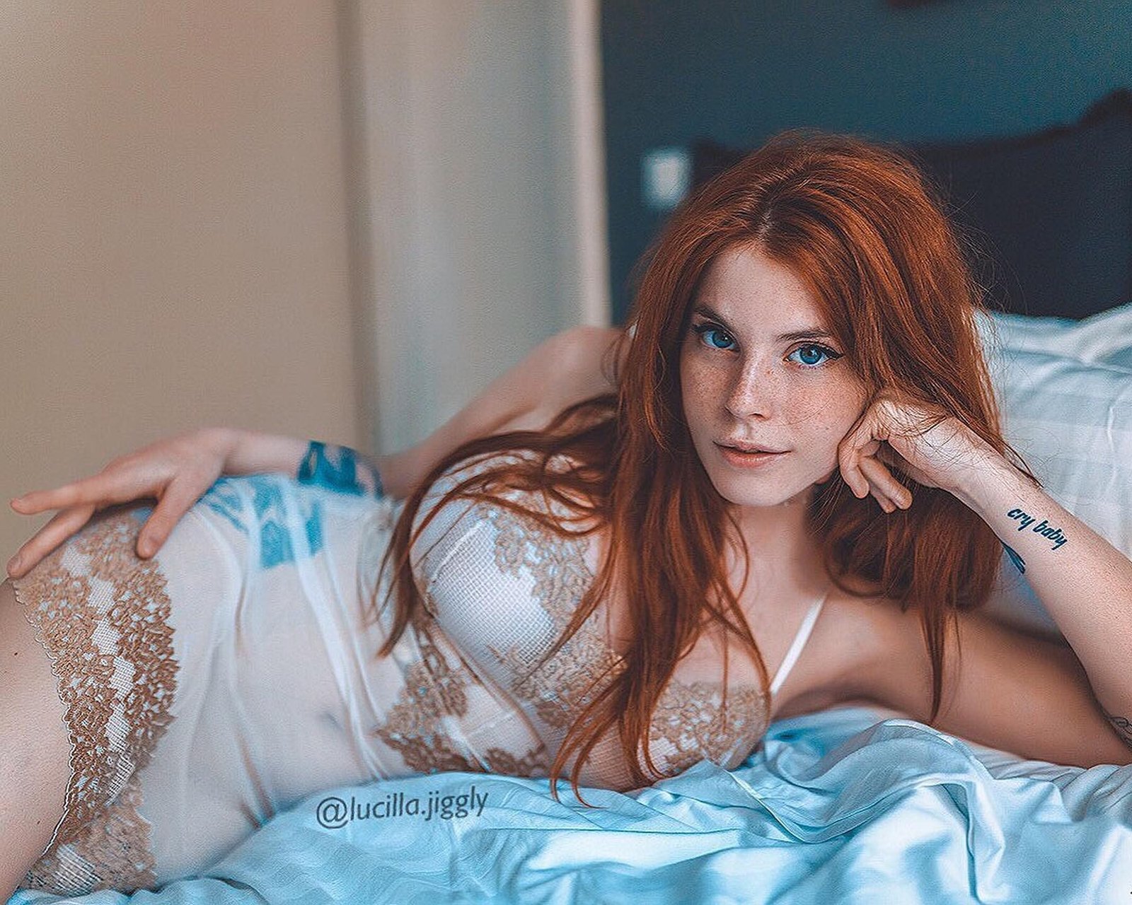 Lucilla Materazzi modelo ruiva deitada na cama de camisola